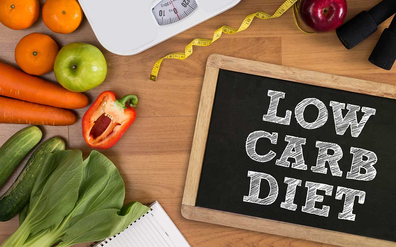 Ein Tisch mit Gemüse und einem Schild mit der Aufschrift Low Carb Diät