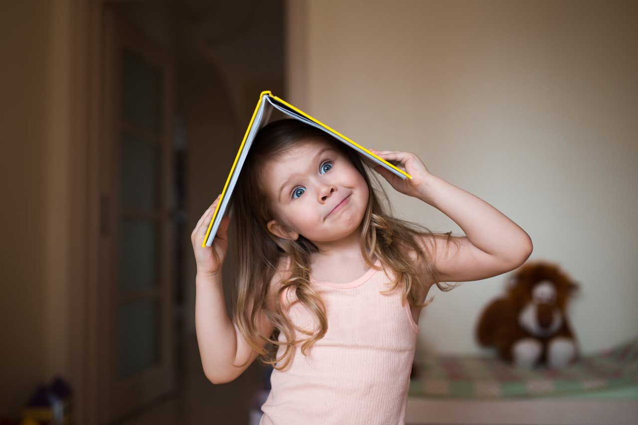 Ein Kind spielt mit einem Buch als Symbol für ADHS